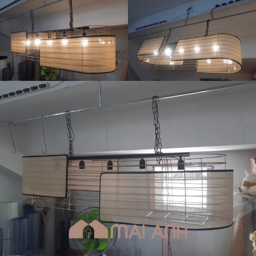 Gia công và hoàn thiện: Mỗi đèn được làm hoàn toàn thủ công, đảm bảo độ cong chính xác của từng nan gỗ để form đèn lên đẹp và đều. Kết hợp cùng bóng LED ánh sáng vàng dịu, bộ ba đèn quả bí ngô đã trở thành điểm nhấn tinh tế cho khu vực bàn ăn của căn hộ.Đèn thả khung sắt uốn cong – Gia công cho showroom nội thất tại Huế Bản thiết kế: Mẫu đèn được thiết kế theo dạng thanh dài, bo cong mềm mại ở hai đầu, sử dụng khung sắt sơn đen kết hợp lớp vải bố đan để tạo hiệu ứng ánh sáng “nửa kín nửa hở” độc đáo. Kiểu dáng này vừa mang tính nghệ thuật cao, vừa giúp ánh sáng xuyên nhẹ, làm nổi bật các vật trưng bày bên dưới. Câu chuyện khách hàng: Đây là đơn đặt hàng đặc biệt từ một đơn vị đèn tại Huế – khách hàng trong ngành, có kinh nghiệm và yêu cầu kỹ thuật rất cao. Anh mong muốn Mai Anh Lighting có thể gia công mẫu đèn giống gần nhất với thiết kế gốc, vì khách hàng cuối cùng của anh là người cực kỳ kỹ tính về thẩm mỹ. Sau quá trình trao đổi kỹ lưỡng giữa hai bên, mẫu đèn cuối cùng đã được chốt và hoàn thiện đúng như hình ảnh phối cảnh ban đầu. Gia công và hoàn thiện: Tại xưởng Mai Anh, khung đèn được tạo hình từ thép hộp uốn cong định hình, với các mối hàn được xử lý siêu mảnh để đảm bảo tính thẩm mỹ và độ bền. Lớp vải bố được căng thủ công từng đoạn, đảm bảo độ phồng đều, không võng, giúp đèn lên form chuẩn như thiết kế. Mỗi chi tiết đều được cân nhắc để giữ được tính đồng bộ khi lắp thành cụm đèn treo trần trong showroom nội thất cao cấp. ✨ Mẫu đèn này là minh chứng cho khả năng phối hợp giữa cơ khí chính xác và thủ công mỹ thuật, giúp Mai Anh Lighting có thể gia công theo yêu cầu đặc thù từ các đơn vị trong ngành đèn – kể cả với những mẫu khó và yêu cầu cao. 5. Đèn cá tua rua đan mây tự nhiên – Công trình nhà hàng tại Thanh Hoá Ý tưởng thiết kế: Mẫu đèn cá tua rua đan mây tự nhiên lấy cảm hứng từ hình dáng mềm mại của cá, kết hợp chất liệu mây tự nhiên để tạo cảm giác gần gũi và nghệ thuật. Đây là mẫu đèn thả trần được thiết kế để làm điểm nhấn trong không gian rộng lớn. Thực tế khách hàng: Anh Tuấn – đại diện bên công trình tại Thanh Hoá – đã liên hệ với Mai Anh Lighting để đặt hàng mẫu đèn cá tua rua với hai kích cỡ: size lớn dài 1m6 và size nhỏ dài 1m. Sau khi hoàn thành bản mẫu, chúng tôi gửi hàng qua dịch vụ vận chuyển tiết kiệm để anh kiểm tra. Nhận được phản hồi tích cực, anh đặt thêm hơn 30 chiếc để trang trí cho không gian chính của nhà hàng. Gia công và hoàn thiện: Để đảm bảo sản phẩm đạt tiêu chuẩn thẩm mỹ và độ bền cao, từng chiếc đèn cá đều được đan thủ công bởi thợ lành nghề. Đặc biệt, mỗi sản phẩm được phủ một lớp keo chống mối mọt nhằm đáp ứng yêu cầu khắt khe của khách hàng, đảm bảo tuổi thọ sản phẩm trong điều kiện thời tiết ẩm. ✨ Đây là một ví dụ điển hình về khả năng gia công sản phẩm nghệ thuật từ mây tre, đáp ứng yêu cầu sáng tạo và chất lượng trong các dự án lớn. 6. Đèn thả mây mắt cáo khung vàng – Dự án phòng tiệc nhà hàng phong cách Đông Dương Thiết kế & chất liệu: Mẫu đèn này được làm dựa trên bản phối cảnh 3D từ khách hàng, với phần chụp đèn tạo hình xếp lớp như cánh hoa nở. Chất liệu chính là khung sắt sơn giả đồng kết hợp mây mắt cáo đan thủ công, mang lại cảm giác vừa cổ điển vừa sang trọng – rất phù hợp với không gian phòng tiệc mang phong cách Đông Dương hiện đại. Thực tế gia công: Ngay từ giai đoạn đầu, Mai Anh Lighting đã trao đổi kỹ với khách về vật liệu và tỉ lệ để lên bản mẫu đúng tinh thần thiết kế. Màu sơn khung vàng đồng được lựa chọn kỹ để hài hoà với tone nội thất gỗ nâu đỏ chủ đạo. Đèn hoàn thiện được lắp đồng bộ theo cụm, tạo thành dải ánh sáng vừa ấm áp vừa nổi bật cho khu vực bàn tiệc chính. ✨ Mẫu đèn này là minh chứng rõ ràng cho khả năng hiện thực hoá thiết kế 3D thành sản phẩm thủ công chất lượng cao – đặc biệt với các vật liệu phối kết cầu kỳ như mây và kim loại. Đèn gỗ kết hợp chao vải – Thi công đèn decor cho phòng thờ tại Bình Dương Mẫu đèn mang phong cách Á Đông trang nhã này được Mai Anh Lighting thực hiện theo đơn đặt hàng từ một chị khách đang làm nội thất ở Bình Dương. Chị chia sẻ rằng khách của chị mong muốn tìm được mẫu đèn trang trí cho phòng thờ – vừa trang nghiêm vừa có nét thẩm mỹ, và rất may mắn khi giữa nhiều lựa chọn ngoài thị trường, chị đã tìm đến chúng tôi. Ngay từ đầu, chị đã thành thật chia sẻ rằng mình không rành lắm về đèn, nên đội ngũ Mai Anh đã hỗ trợ tư vấn rất chi tiết: từ kích thước, màu sơn gỗ, đến cả kiểu hoa văn cần in lên lớp chao vải phía trong. Tất cả được lựa chọn kỹ lưỡng để đảm bảo đèn lên đúng tinh thần truyền thống, không quá nặng nề nhưng vẫn giữ được sự chỉn chu cần có. Mẫu đèn được hoàn thiện trong chưa tới 7 ngày. Khi chúng tôi gửi ảnh sản phẩm cho chị xem trước lúc giao, chị đã thở phào nhẹ nhõm – yên tâm rằng khách mình chắc chắn sẽ hài lòng. 🙏 Mẫu đèn này không chỉ là sản phẩm chiếu sáng, mà còn là kết quả của quá trình lắng nghe và đồng hành cùng khách hàng – đặc biệt là những người đang chăm chút cho không gian linh thiêng của ngôi nhà. 10. Đèn chùm chao vải nhún – Trang trí phòng khách trần cao Mẫu đèn chùm này là lựa chọn lý tưởng cho không gian phòng khách trần cao, cần điểm nhấn mềm mại và ấm áp. Kích thước ngang 120cm, thiết kế hai tầng chao vải xếp nhún, tổng cộng 10 chao vải được bố trí đối xứng tạo hiệu ứng bông hoa bung nở khi nhìn từ dưới lên. Đây là sản phẩm đòi hỏi nhiều công đoạn thủ công: vải nhún được tạo bằng tay – ba tấm vải thường mới làm nên một tấm nhún đạt chuẩn; khung sắt cũng được thợ chỉnh sửa nhiều lần để đảm bảo từng nhánh đèn thẳng và đều. Độ hoàn thiện mẫu đạt đến 90% so với bản thiết kế ban đầu – một kết quả khiến cả xưởng rất tự hào. Chiếc đèn không chỉ đẹp ở hình dáng mà còn tỏa ánh sáng vàng ấm dịu, giúp tổng thể không gian phòng khách thêm phần sang trọng, đậm chất nghệ thuật. 10. Bộ 3 đèn thả vải hình khối – Gia công theo bản thiết kế tại TP.HCM Thiết kế ban đầu: Bộ đèn này được khách gửi trực tiếp bản vẽ phối cảnh với mong muốn làm từ chất liệu gỗ hoặc mây. Mỗi mẫu mang một hình khối khác biệt – từ tròn tầng, vuông hộp đến dáng xoè đáy – đòi hỏi tạo hình chính xác để giữ được hiệu ứng phân tầng ánh sáng. Thực tế gia công: Sau khi xem xét thiết kế, đội thợ bên Mai Anh nhận định rằng chất liệu gỗ/mây sẽ khó đảm bảo độ uốn mềm và form sắc nét như trong hình vẽ. Do đó, chúng tôi đề xuất chuyển sang khung sắt kết hợp bọc vải cao cấp, vừa nhẹ vừa dễ tạo nếp. Kết quả: sản phẩm hoàn thiện giữ nguyên form thiết kế, ánh sáng xuyên vải tạo hiệu ứng tầng đẹp mắt và sang trọng. Top 10 Mẫu Đèn Gia Công Theo Thiết Kế Hot Nhất Nửa Đầu 2025
